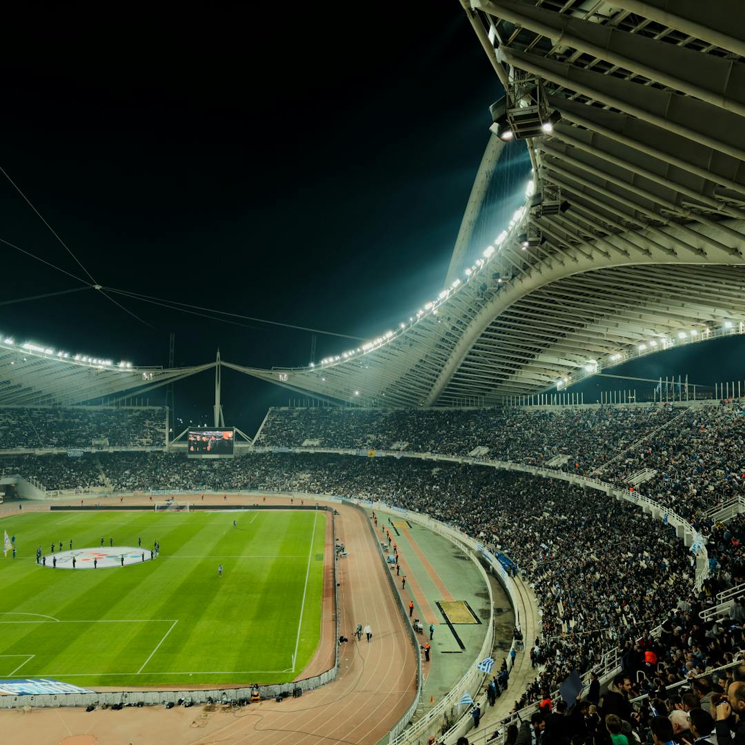 Illuminated soccer stadium at night with crowd
